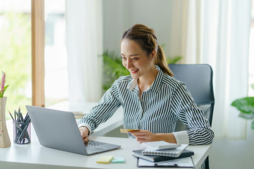 Asian businesswoman using laptop to check balance and online shopping enjoy online shopping