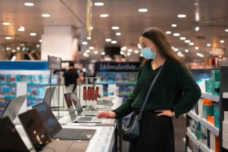 Woman choosing laptop in mall